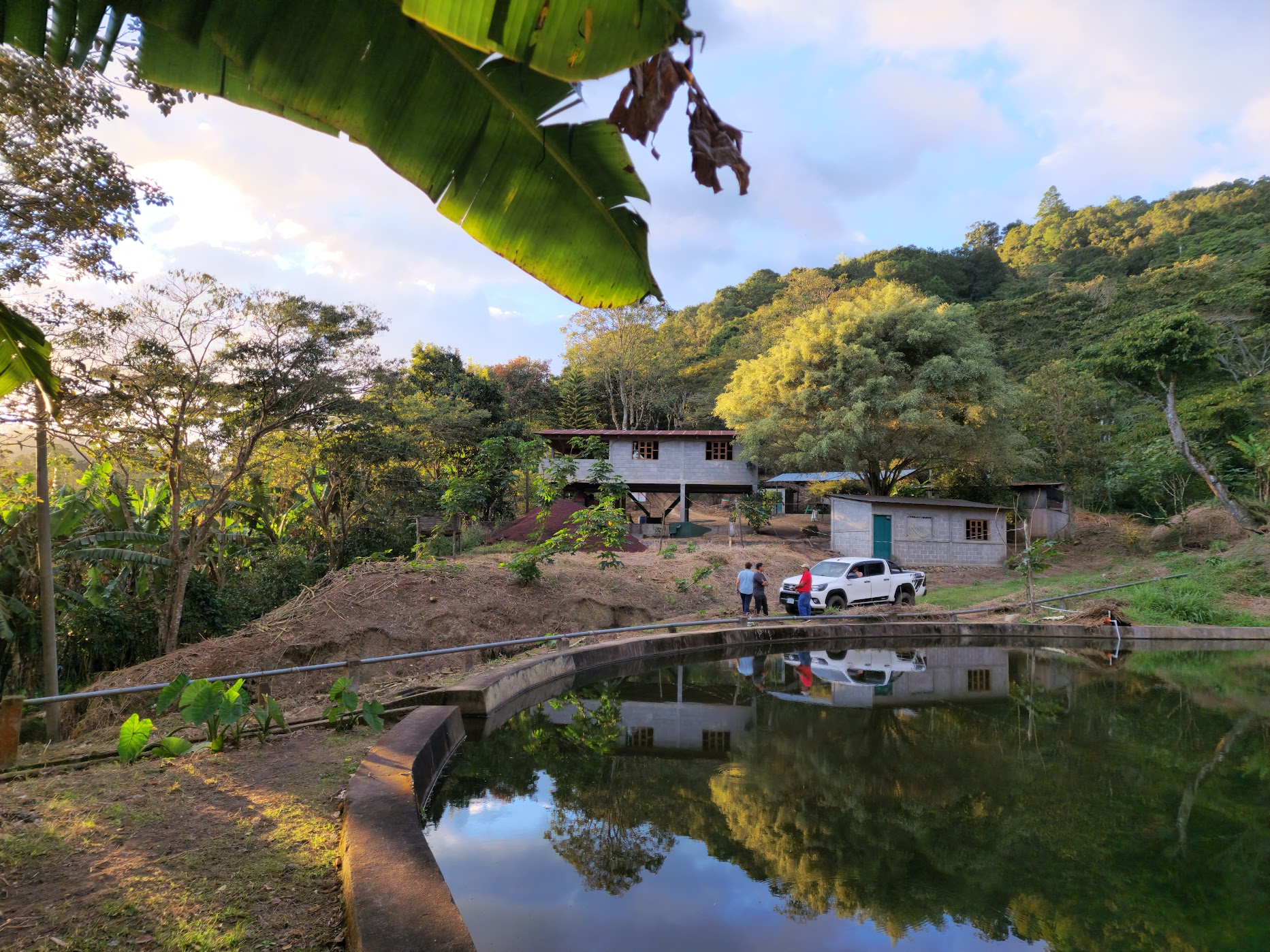 A 4x4 pickup at a remote coffee farm beside a water reservoir in the Nicaraguan hills